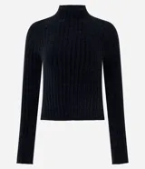 Blusa cropped de punto chenille color negro, con cuello alto y mangas largas raglán. Presenta una textura acanalada y pequeños puntos brillantes aplicados en el frente.