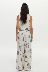 Pantalón de pierna ancha, confeccionado en lino, con cintura elástica con cordón de ajuste y estampado en tonos azules sobre base cruda.