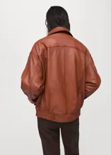 Chaqueta de cuero de ovino en color marrón, de diseño oversize con cuello clásico, cierre frontal con botones a presión y bolsillos frontales con solapa.