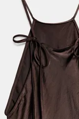 Vestido midi de Zara Woman Collection confeccionado en tejido satinado color marrón chocolate. Presenta un diseño de cuello halter con tirantes finos ajustables mediante lazada en la espalda y una caída fluida.