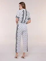 Pantalon crop de corte recto y calce fluido con textura liviana, color blanco con estampado a contraste, cintura elastizada y bolsillos laterales.