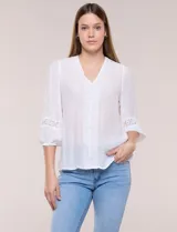 Blusa blanca de manga larga con escote en V y detalles de encaje en la botonera frontal, cuello y puños.
