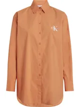 Camisa color naranja de algodón con corte holgado, cuello clásico, cierre frontal con botones y logo bordado en el pecho.