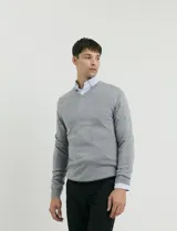 Sweater de punto con escote en V y manga larga, con puños y ruedo acanalados.
