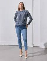 Blusa de gasa estampada con líneas verticales negras sobre fondo beige, de manga larga con puño abotonado. Espalda con abertura y botón.