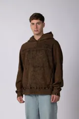 Buzo canguro oversize con efecto lavado desgastado, confeccionado en friza pesada. Presenta diseño con recortes, capucha amplia y puños y ruedo acanalados.