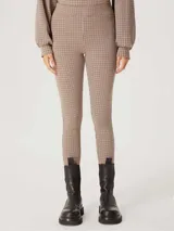 Pantalón legging de tela escocesa en tonos beige, marrón y negro.