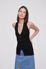 Top negro sin mangas de viscosa, corte al cuerpo, con botones y cuello halter.