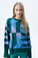 Sweater de tejido de punto con diseño geométrico multicolor en tonos verde, azul y lila. Presenta cuello redondo, mangas largas con puños acanalados y corte recto.