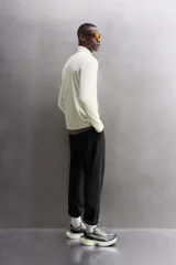 Camiseta de manga larga negra, confeccionada en tejido técnico ligero y elástico. Tiene cuello alto con cremallera, corte slim fit, bolsillo frontal con cremallera y puños con cinta a contraste.