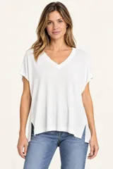 Remera de punto blanco con cuello en V, mangas cortas y aberturas laterales en el dobladillo.