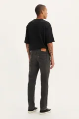 Pantalón de jean corte slim fit, color gris oscuro con efecto lavado, de tiro medio y cierre frontal con botón y cremallera.