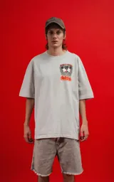 Remera de algodón premium color gris claro, corte oversize, con cuello redondo y manga corta. Presenta un estampado frontal pequeño con dos personajes de Disney (Mickey y Minnie) en llamas con el texto "THE FLAME OF LOVE".