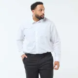 Camisa de manga larga con corte regular fit, color blanco con estampado de pequeños puntos negros. Presenta cuello clásico y cierre frontal con botones.