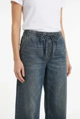 Pantalon fluido estilo denim de corte ancho, color gris, con cintura elastizada y cordón ajustable.
