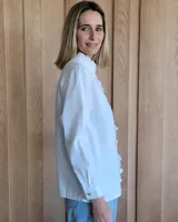 Camisa de jean azul con cuello alto con volados y volados en el frente.