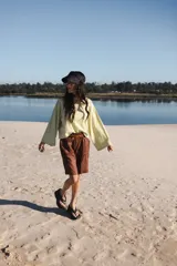 Remera de mangas largas a rayas horizontales verdes y blancas, de corte amplio y cuello redondo.