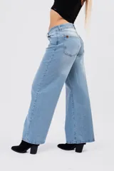 Pantalón wide leg de tiro medio-bajo, con corte holgado y pernera ancha. Presenta un diseño clásico de cinco bolsillos con cierre de botón y cremallera, en un tono azul claro con acabado lavado.