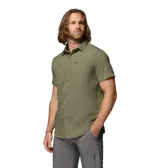 Camisa de manga corta Columbia, color verde oliva, con cuello clásico, cierre frontal de botones y dos bolsillos frontales en el pecho. Presenta un diseño técnico con ventilación en la espalda, ideal para actividades al aire libre.