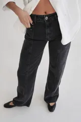 Pantalón de jean recto de tiro medio, con costuras verticales decorativas en el frente y bolsillos laterales. Presenta un diseño de lavado desgastado en tono gris.