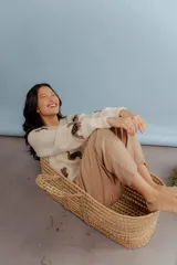 Buzo de lana merino color crema, con diseño tejido de llamas en tonos marrones. Presenta cuello redondo, mangas largas con hombros caídos y puños acanalados.