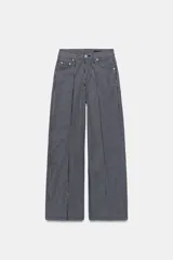 Jeans wide leg de tiro alto y diseño relaxed fit, confeccionados en denim azul marino con patrón de rayas verticales blancas. Cuenta con cinco bolsillos, cierre frontal con cremallera y botón, y detalle de nervio delantero con pespuntes a contraste.