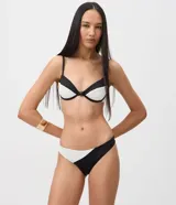 Bombacha de bikini de microfibra con diseño color block en blanco y negro, con recorte lateral texturado y detalle metálico.