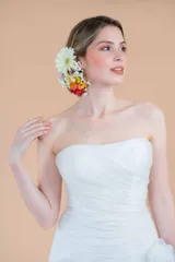 Vestido de novia blanco de organza, con corset drapeado, falda con volados y cola larga. Presenta un delicado bordado de perlas en la cintura.