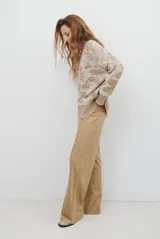 Buzo de tejido de punto con cuello redondo, mangas largas con puños acanalados y diseño estampado de flores en tonos rojos.