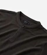 Chomba celeste de corte slim, confeccionada en tejido piquet texturizado de algodón, con cuello mao y cierre frontal parcial con botones.