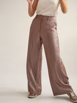 Pantalon de vestir de corte recto y tiro medio-alto, confeccionado en crepe con acabado metalizado lurex. Presenta pretina con detalle de sesgo a contratono, cierre frontal y bolsillos laterales.