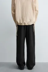 Pantalón de corte regular fit confeccionado en mezcla de algodón y lino. Presenta cintura elástica con cordón ajustable, cierre frontal con cremallera y botón, bolsillos laterales y bolsillo trasero de vivo con botón.