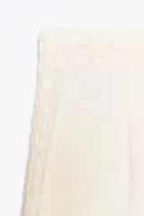 Shorts de tiro medio color crudo, confeccionados en hilatura de algodón con detalle de aplicación de crochet.