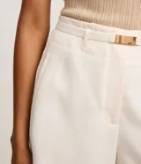 Short sastre de corte recto color blanco, con cintura alta, trabillas y cinturón integrado con hebilla metálica.