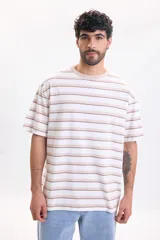 Remera oversize de manga corta con diseño de rayas horizontales en tonos beige, marrón y blanco, con cuello redondo.