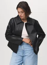Chaqueta corta de efecto piel en color negro, con cuello de solapa, cierre frontal de botones y dos bolsillos de parche con solapa en la parte delantera. Presenta un diseño recto y forro interior.