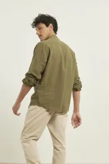 Camisa de cuello mao y manga larga, confeccionada en una mezcla de lino y algodón. Presenta un diseño de corte recto con botones en tono natural y un bolsillo pequeño en el pecho.