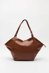 Bolso negro tipo tote de cuero sintético con acabado soft touch, asas largas regulables y diseño minimalista.