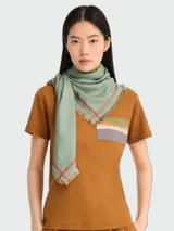 Pañuelo estilo chal cuadrado color verde menta con patrón jacquard, diseño de medallas y bordes con líneas rojizas y flecos.