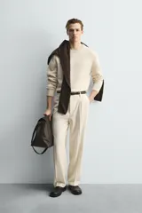 Jersey de punto relaxed fit confeccionado en mezcla de lana y fibra de alpaca, con textura ligera y efecto pelo. Presenta cuello redondo, manga larga y acabados en rib en puños y cintura.