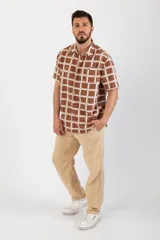 Camisa de manga corta con estampado a cuadros marrones, blancos y azules.