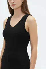 Musculosa de algodón color blanco, con tirantes anchos, escote en V cruzado y diseño asimétrico de canalé.