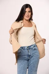 Camisa de pana fina color beige, con cuello clásico, cierre frontal de botones y dos bolsillos con solapa en el pecho.