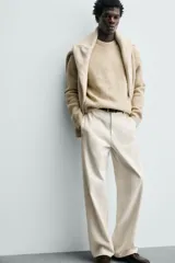 Sweater de punto color beige, de corte relajado, con cuello redondo y diseño texturizado en estructura waffle.