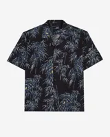 Camisa de manga corta negra con estampado de bambú en tonos azules y amarillos, cuello cuban y cierre frontal de botones.