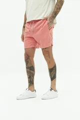 Short de baño liso con cintura elástica y cordón ajustable. Cuenta con dos bolsillos laterales, un bolsillo trasero y logo bordado en el ruedo. Confeccionado en tejido ligero de secado rápido.