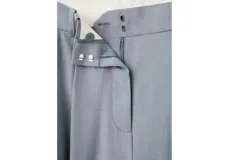 Pantalón de vestir color celeste, de corte recto y pernera ancha, con pinzas delanteras y bolsillos laterales.