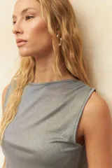 Top sin mangas de color negro, confeccionado en tejido elastizado con diseño de frunces laterales y cuello redondo.