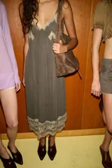 Vestido midi estilo lencero color verde oscuro, con escote en pico, tirantes finos ajustables y detalles de encaje a contraste en el escote y el ruedo.