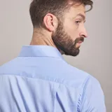 Camisa negra de algodón con cuello clásico, manga larga y cierre frontal con botones. Presenta un logo bordado en el pecho. Corte entallado.